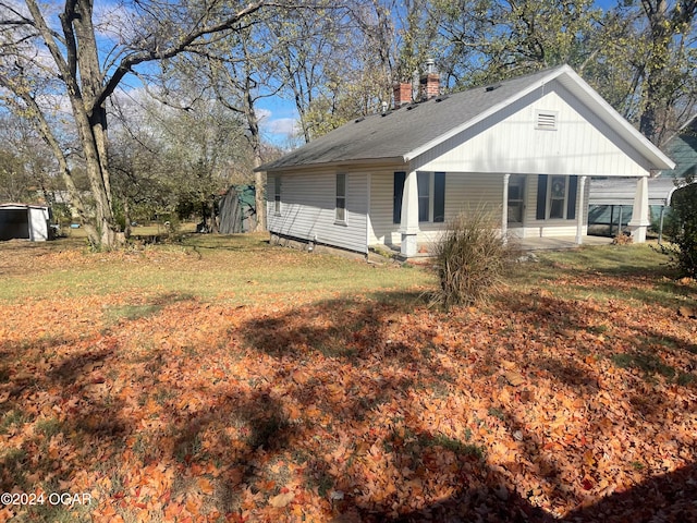 view of side of home with a lawn and a porch