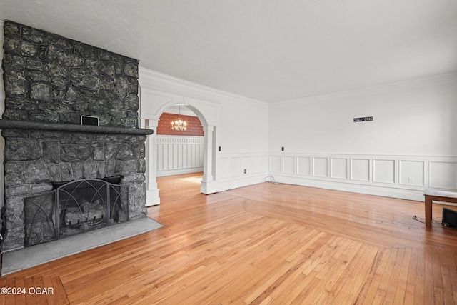 unfurnished living room featuring crown molding, wood-type flooring, and a fireplace