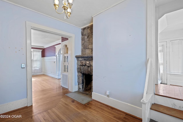 unfurnished dining area featuring crown molding, hardwood / wood-style flooring, and a chandelier