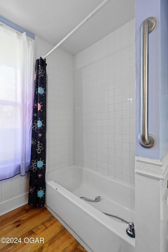 bathroom with shower / bath combo with shower curtain and wood-type flooring