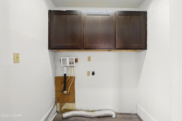 clothes washing area featuring hookup for a washing machine, electric dryer hookup, wood-type flooring, and cabinets