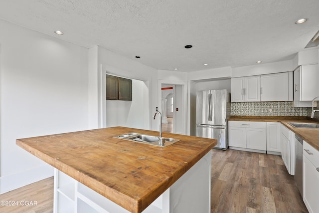 kitchen featuring a center island, white cabinetry, stainless steel appliances, and sink