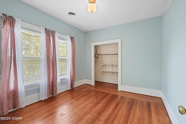 spare room with a textured ceiling and hardwood / wood-style flooring