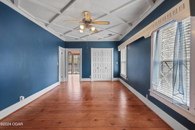 unfurnished room with a wealth of natural light, coffered ceiling, wood-type flooring, and ceiling fan