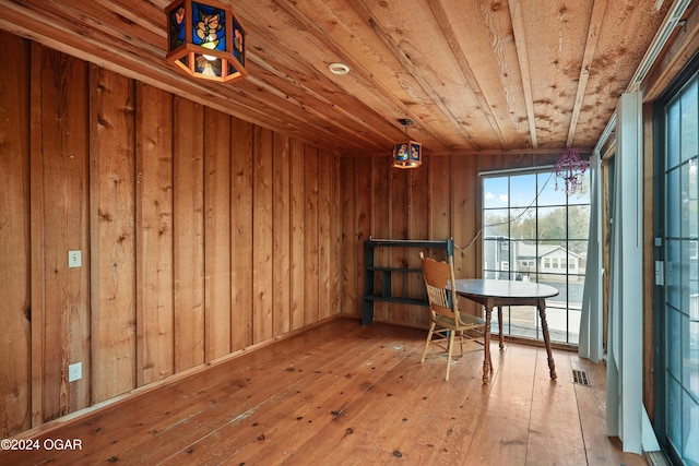 interior space with wood walls, hardwood / wood-style flooring, and wooden ceiling