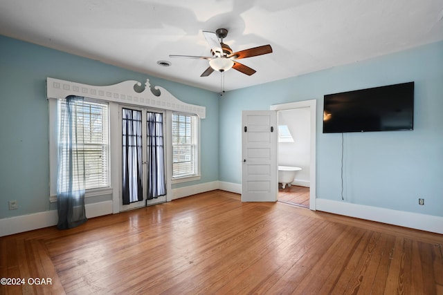 interior space featuring hardwood / wood-style floors, connected bathroom, and ceiling fan