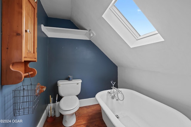 bathroom featuring a tub to relax in, lofted ceiling with skylight, hardwood / wood-style floors, and toilet