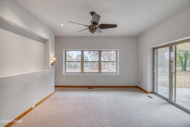 spare room featuring light colored carpet and ceiling fan