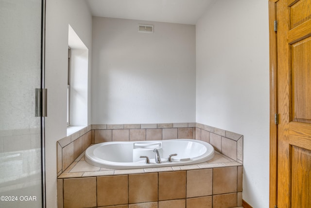 bathroom featuring independent shower and bath