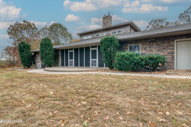 rear view of house with a lawn and a sunroom