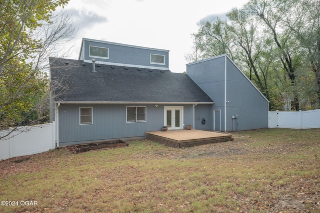 back of property with a yard and a wooden deck