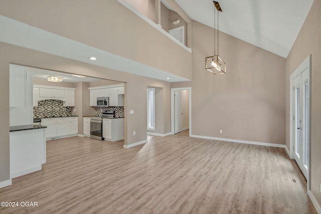 unfurnished living room featuring light hardwood / wood-style floors, high vaulted ceiling, and plenty of natural light