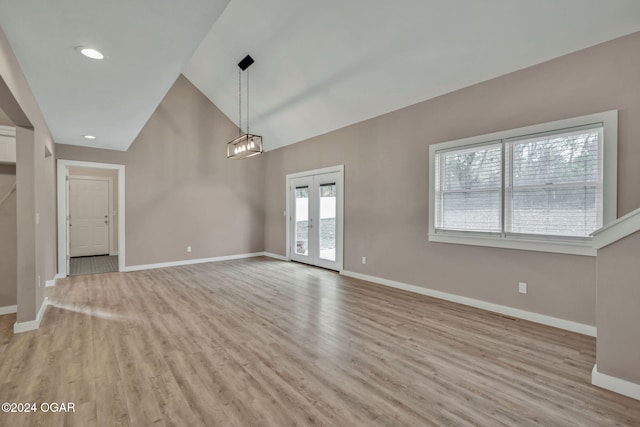 interior space featuring french doors, a notable chandelier, high vaulted ceiling, and light hardwood / wood-style flooring