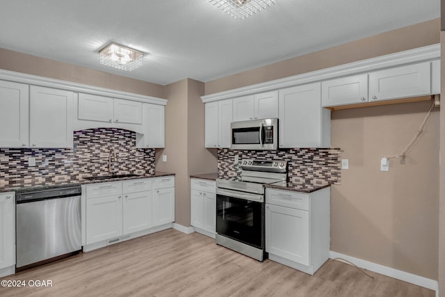 kitchen featuring sink, white cabinets, stainless steel appliances, and light hardwood / wood-style floors