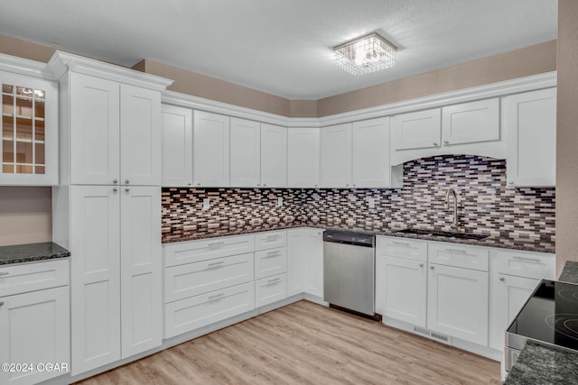 kitchen featuring appliances with stainless steel finishes, sink, white cabinetry, decorative backsplash, and light hardwood / wood-style flooring