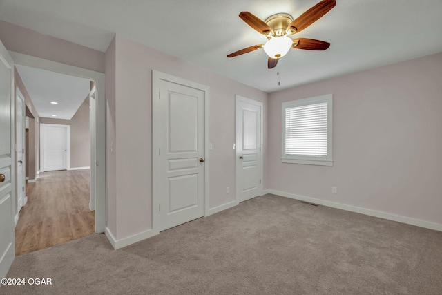 unfurnished bedroom with light carpet, a closet, and ceiling fan