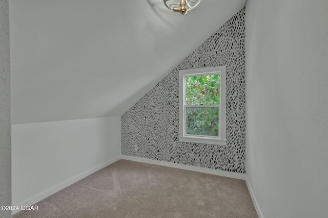 additional living space featuring carpet flooring and lofted ceiling