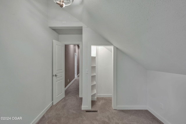 bonus room featuring light carpet, a textured ceiling, and vaulted ceiling