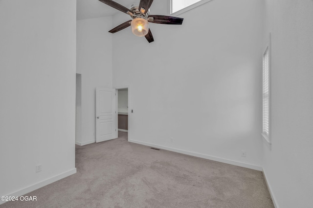 unfurnished room featuring light carpet, high vaulted ceiling, and ceiling fan