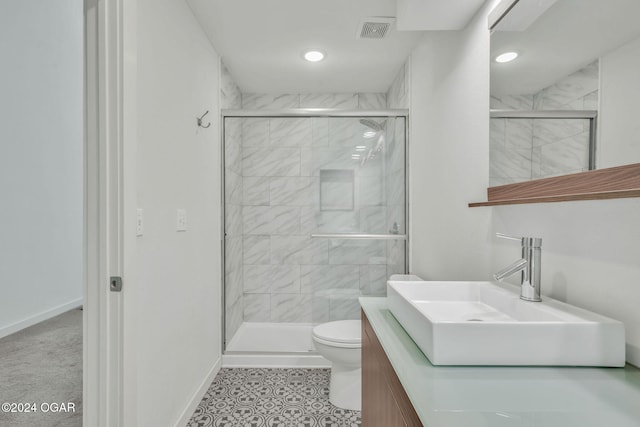 bathroom with vanity, toilet, and a shower with door