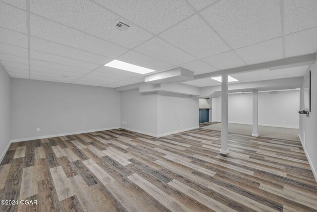 basement with a drop ceiling and wood-type flooring