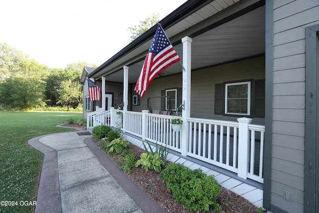 view of side of property with covered porch and a lawn