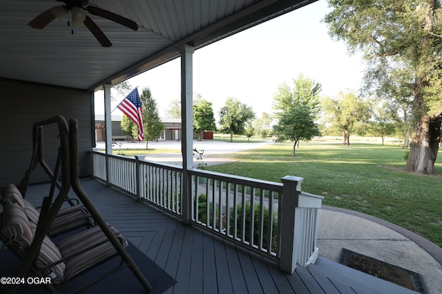 wooden terrace featuring a lawn and ceiling fan