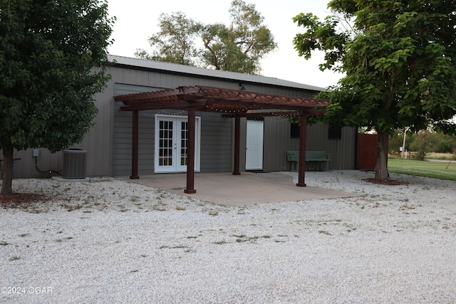 rear view of property featuring french doors, central AC unit, and a carport