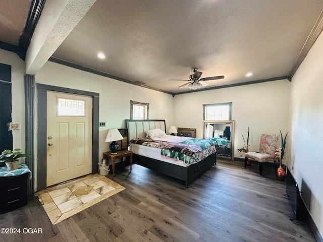 bedroom with ornamental molding, dark wood-type flooring, and ceiling fan