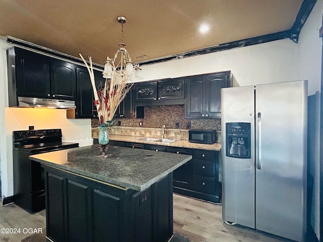 kitchen with sink, black appliances, decorative light fixtures, light hardwood / wood-style flooring, and a center island