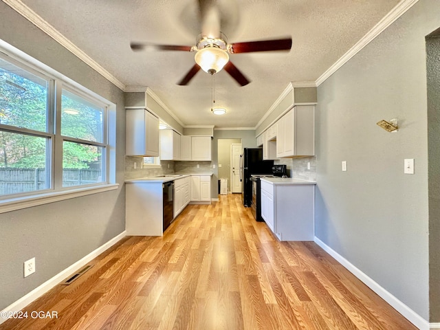 kitchen featuring white cabinetry, backsplash, black appliances, and light hardwood / wood-style flooring