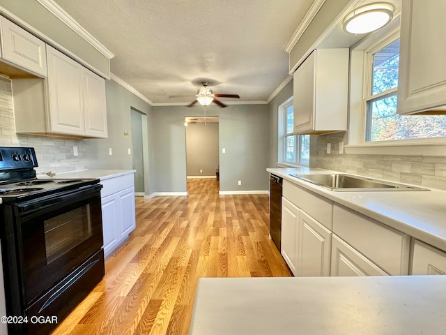 kitchen featuring white cabinets, black appliances, and plenty of natural light