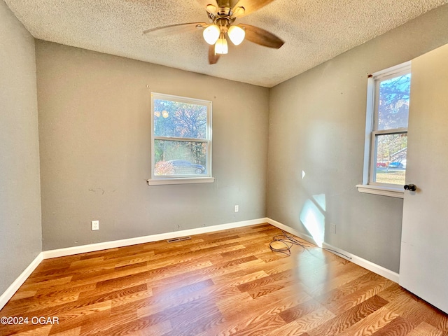 unfurnished room with ceiling fan, a textured ceiling, and light hardwood / wood-style flooring