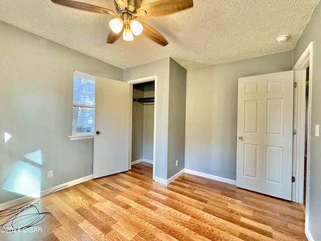 unfurnished bedroom with light hardwood / wood-style flooring, a closet, a textured ceiling, and ceiling fan