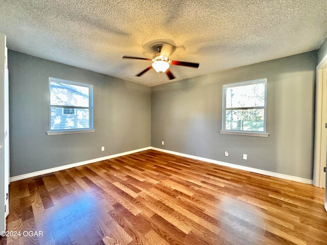 empty room with a textured ceiling, light wood-type flooring, and ceiling fan