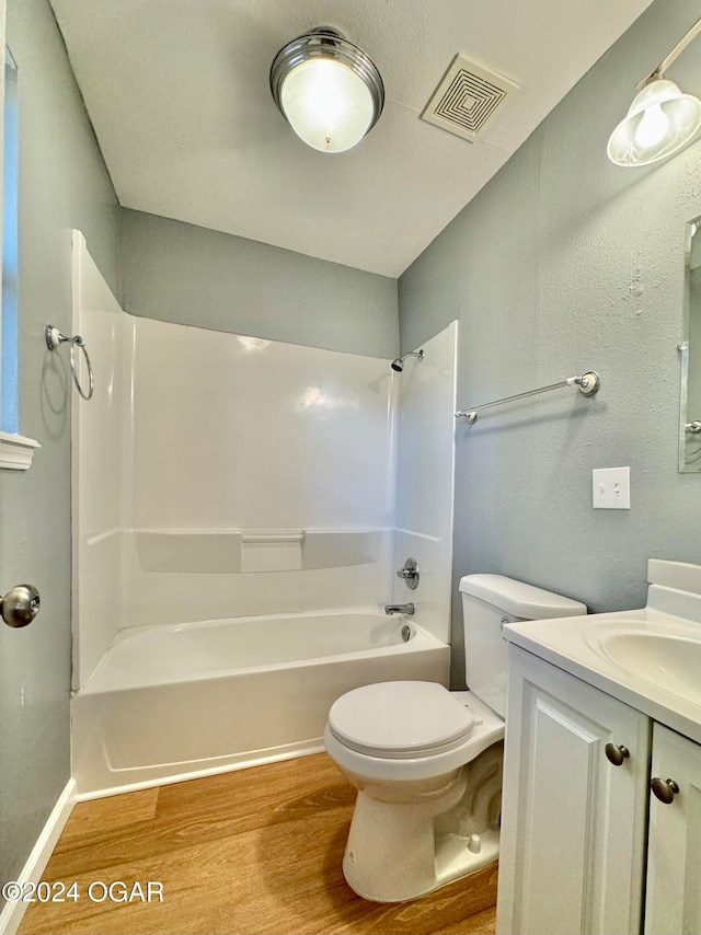 full bathroom with vanity, hardwood / wood-style floors, shower / tub combination, and toilet