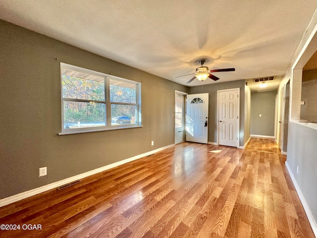 interior space featuring a textured ceiling, light hardwood / wood-style floors, and ceiling fan