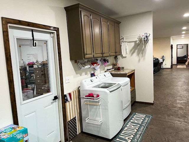 clothes washing area featuring cabinets and washer and clothes dryer