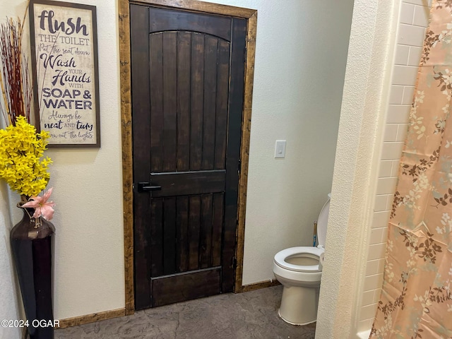 full bathroom with toilet and baseboards