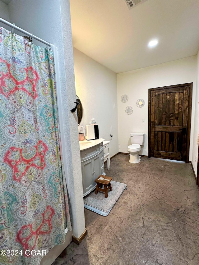 bathroom featuring curtained shower, vanity, toilet, and baseboards