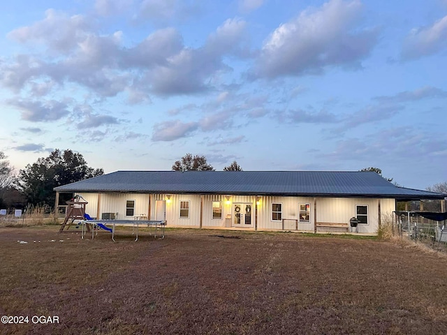 back of house featuring metal roof, french doors, and a trampoline