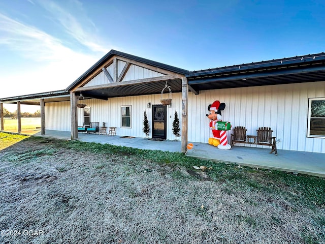 rear view of property with a lawn and a patio