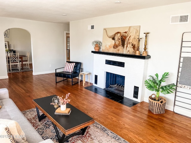 living room with wood-type flooring and a fireplace