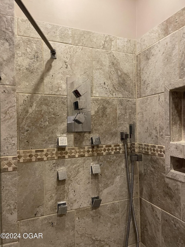 interior details featuring a tile shower