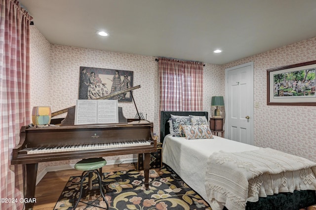 bedroom with recessed lighting, wood finished floors, and wallpapered walls