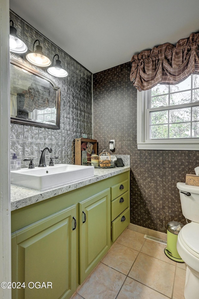 bathroom with wallpapered walls, visible vents, toilet, tile patterned floors, and vanity