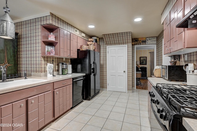 kitchen featuring range hood, light countertops, black appliances, and wallpapered walls