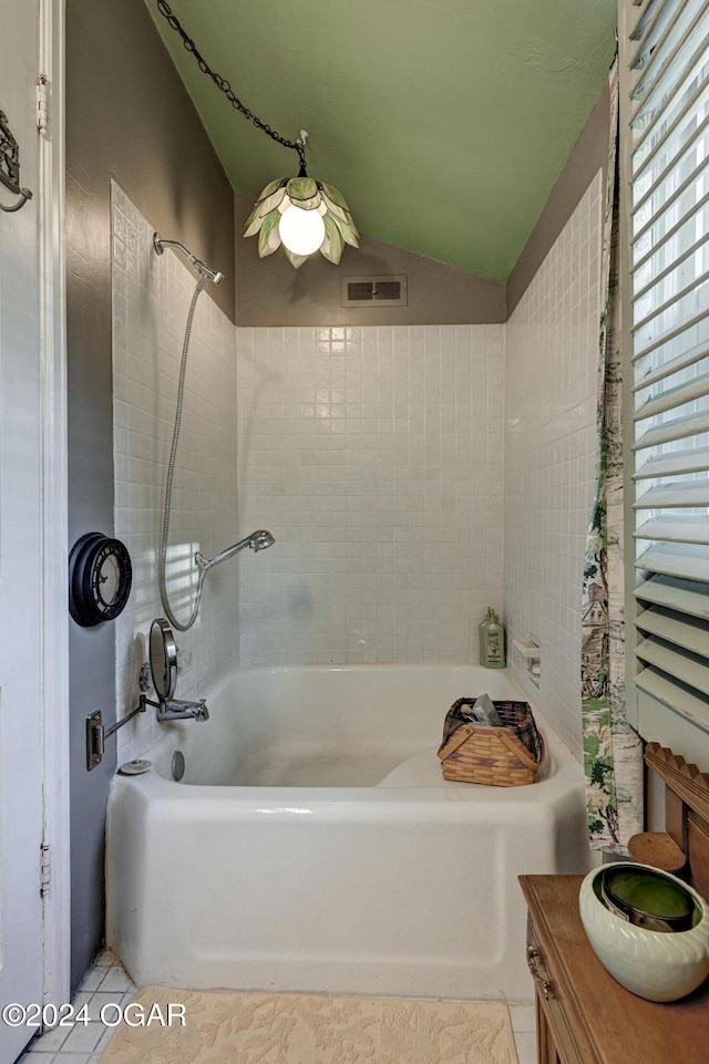 full bathroom featuring lofted ceiling, visible vents, tub / shower combination, vanity, and tile patterned flooring