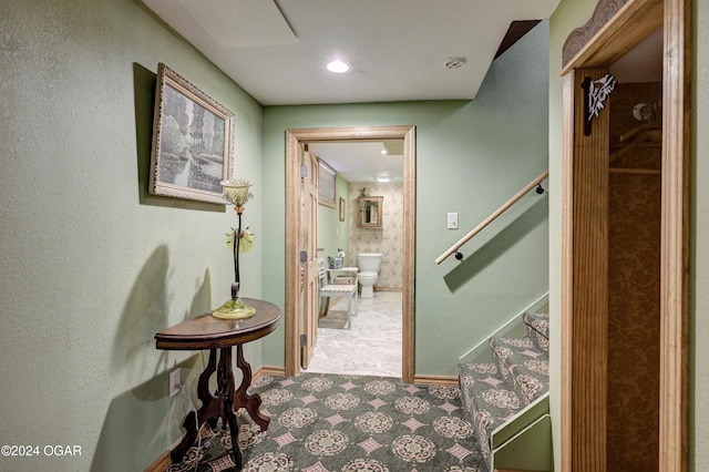 hallway featuring stairway and baseboards