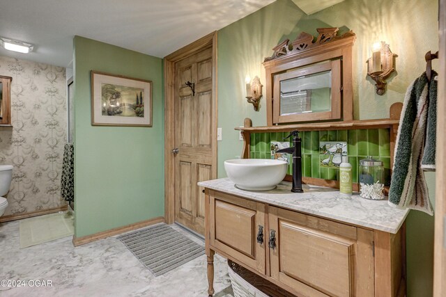 114 W F St, Joplin, MO 64801 - bathroom with vanity, toilet, marble look tile flooring, and baseboards